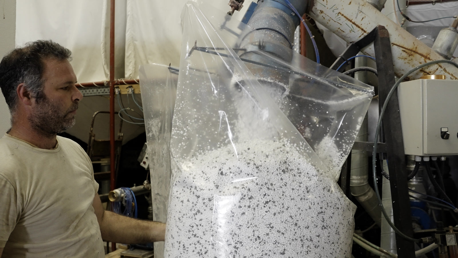 Operator collecting processed EPS in a large industrial bag (2026)